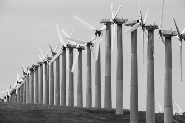 A row of wind turbines on a hill, forming a histogram shape.