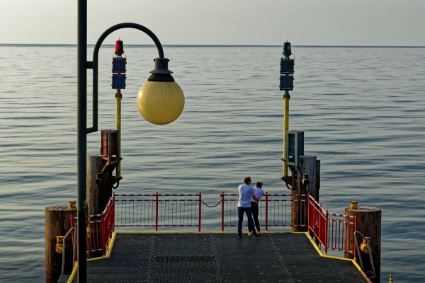 A couple standing on the closed part of the pier in Międzyzdroje, Poland. The photo was taken in late afternoon, so colors are a bit weird.