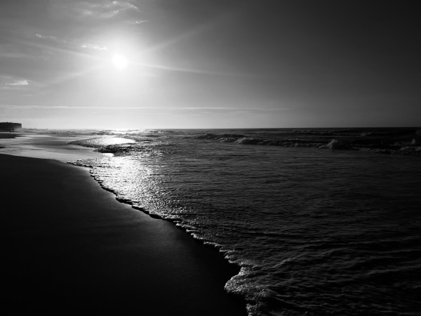 This photograph was taken in the early morning hours as I was walking along the beach in Ocean City, NJ. The rays of the sun were causing the water to shimmer all along the shoreline. I chose to capture this image in black and white in order to emphasize the contrast between the light of the sun, the darkness of the ocean and the shadows on the beach.