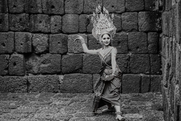 Apsara dancer with elaborate headdress and costume in temple ruins